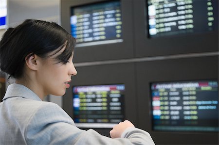 simsearch:625-02932602,k - Gros plan d'une femme d'affaires vérifier le temps dans un aéroport Photographie de stock - Premium Libres de Droits, Code: 625-02929616