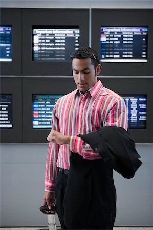 Businessman checking the time at an airport Stock Photo - Premium Royalty-Free, Code: 625-02929620