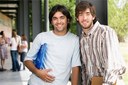 Portrait of two male university students standing in a corridor and smiling Stock Photo - Premium Royalty-Free, Code: 625-02929666