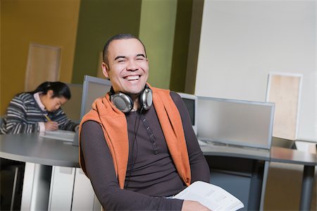 simsearch:625-02929867,k - Portrait of a young man sitting in a computer lab and laughing Fotografie stock - Premium Royalty-Free, Codice: 625-02929710