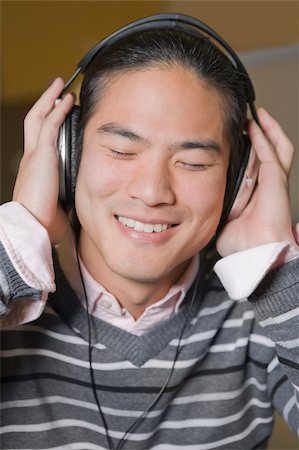 simsearch:625-01746391,k - Close-up of a young man listening to music and smiling Foto de stock - Sin royalties Premium, Código: 625-02929726