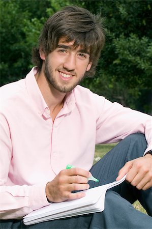 simsearch:625-02930319,k - Portrait of a young man writing with a pen on a notepad Stock Photo - Premium Royalty-Free, Code: 625-02929739