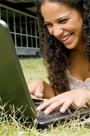 simsearch:625-02932275,k - Close-up of a teenage girl working on a laptop and smiling Fotografie stock - Premium Royalty-Free, Codice: 625-02929765