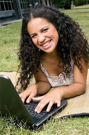 Portrait of a teenage girl working on a laptop and smiling Stock Photo - Premium Royalty-Free, Code: 625-02929785
