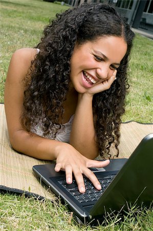 simsearch:625-02932275,k - Close-up of a teenage girl working on a laptop and smiling Fotografie stock - Premium Royalty-Free, Codice: 625-02929795