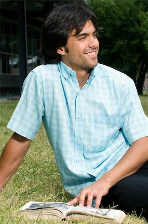 excited college student with books - Close-up of a young man sitting on grass and smiling Stock Photo - Premium Royalty-Free, Code: 625-02929846