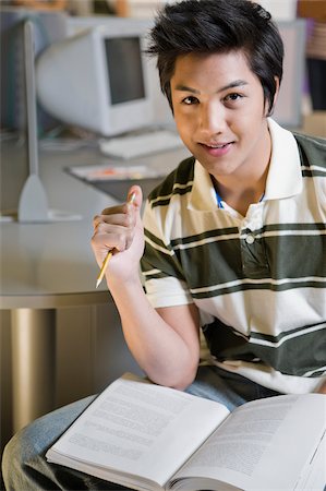 simsearch:625-02929867,k - Portrait of a young man sitting in a computer lab and smiling Fotografie stock - Premium Royalty-Free, Codice: 625-02929858