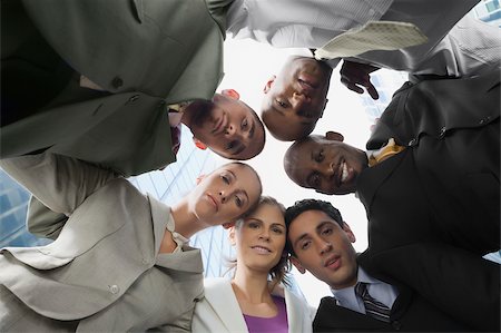 Low angle view of business executives standing in a huddle Stock Photo - Premium Royalty-Free, Code: 625-02929897