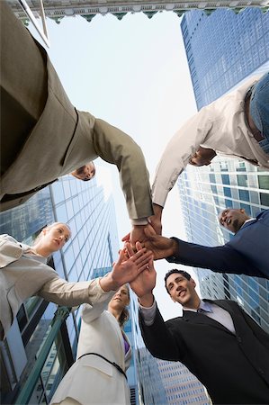 Low angle view of business executives standing in a huddle Stock Photo - Premium Royalty-Free, Code: 625-02929907