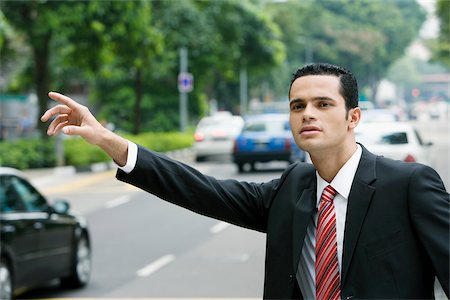 simsearch:625-02930848,k - Close-up of a businessman hailing for a vehicle Fotografie stock - Premium Royalty-Free, Codice: 625-02929965