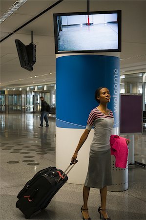Businesswoman pulling her luggage at an airport Stock Photo - Premium Royalty-Free, Code: 625-02929978