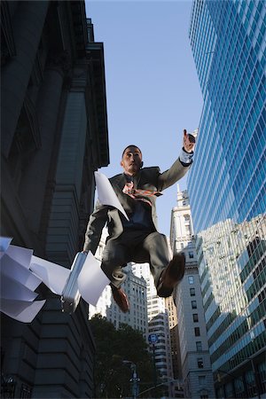 people running with briefcases - Low angle view of a businessman in mid-air Stock Photo - Premium Royalty-Free, Code: 625-02929999