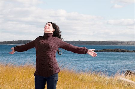 simsearch:632-03652079,k - Mature woman standing on the beach with her arms outstretched Fotografie stock - Premium Royalty-Free, Codice: 625-02930069