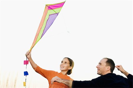 Rear view of a mid adult man with his daughter flying a kite Foto de stock - Sin royalties Premium, Código: 625-02930103