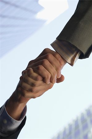 Low angle view of two people shaking hands Stock Photo - Premium Royalty-Free, Code: 625-02930166