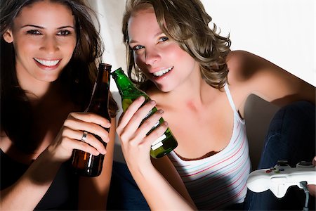 simsearch:625-02932991,k - Portrait of two young women toasting with beer bottles and smiling Stock Photo - Premium Royalty-Free, Code: 625-02930214