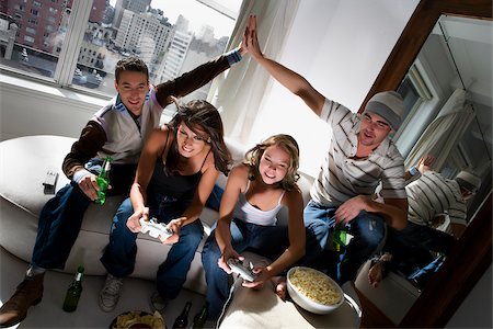 Two young women playing video game and two young men making high five beside them Stock Photo - Premium Royalty-Free, Code: 625-02930215