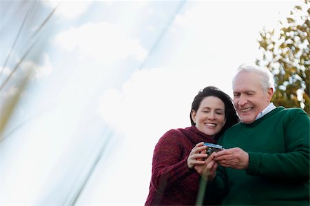 Couple looking at a digital camera and smiling Stock Photo - Premium Royalty-Free, Code: 625-02930260