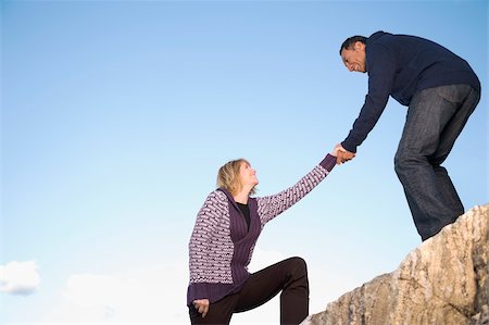 Mature man helping a mature woman to climb a rock Stock Photo - Premium Royalty-Free, Code: 625-02930274