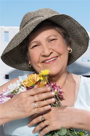 simsearch:625-02932391,k - Close-up of a senior woman holding a bunch of flowers and smiling Stock Photo - Premium Royalty-Free, Code: 625-02930294