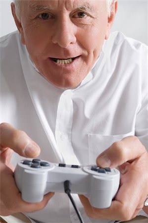 Close-up of a senior man playing a video game Fotografie stock - Premium Royalty-Free, Codice: 625-02930297