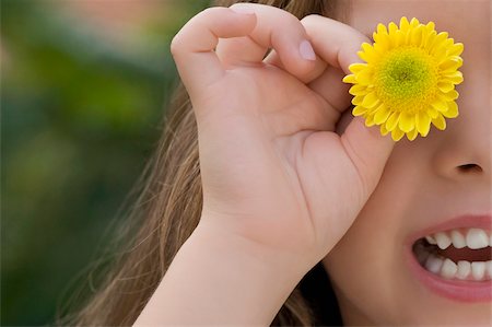flower head - Close-up of a girl holding a flower on her eye Stock Photo - Premium Royalty-Free, Code: 625-02930381