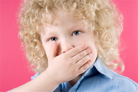 portrait little boy blonde curly hair - Close-up of a boy covering his mouth with his hands Stock Photo - Premium Royalty-Free, Code: 625-02930382