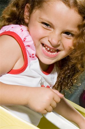 simsearch:693-06967402,k - Gros plan d'une jeune fille dans une voiture de jouet et souriant Photographie de stock - Premium Libres de Droits, Code: 625-02930400