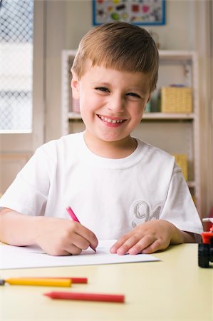 simsearch:625-02267229,k - Portrait d'un garçon de dessin sur une feuille de papier et souriant Photographie de stock - Premium Libres de Droits, Code: 625-02930524