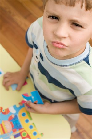 desk directly above - Portrait of a boy holding a puzzle piece Stock Photo - Premium Royalty-Free, Code: 625-02930539