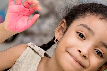 Portrait of a girl showing paint covered hand and smiling Stock Photo - Premium Royalty-Free, Code: 625-02930533