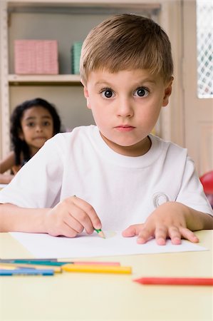 Portrait of a boy drawing on a sheet of paper with a girl sitting behind him Foto de stock - Sin royalties Premium, Código: 625-02930548