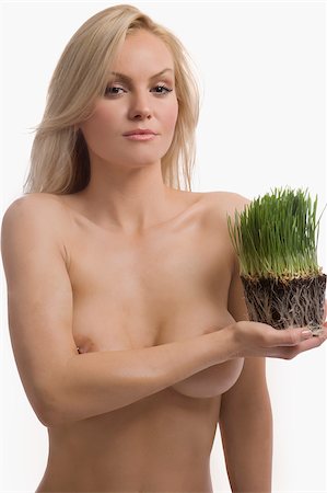 Portrait of a young woman holding wheatgrass Stock Photo - Premium Royalty-Free, Code: 625-02930682