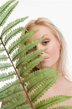 simsearch:625-02930713,k - Portrait of a young woman holding a frond Stock Photo - Premium Royalty-Free, Code: 625-02930724