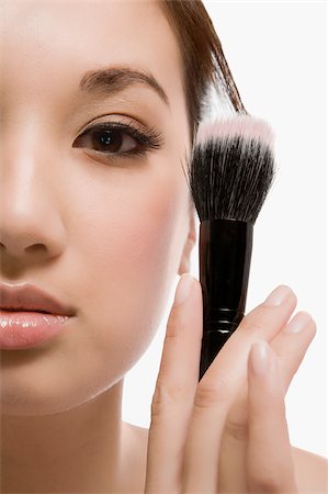 simsearch:700-02637579,k - Close-up of a young woman holding a make-up brush Foto de stock - Sin royalties Premium, Código: 625-02930737