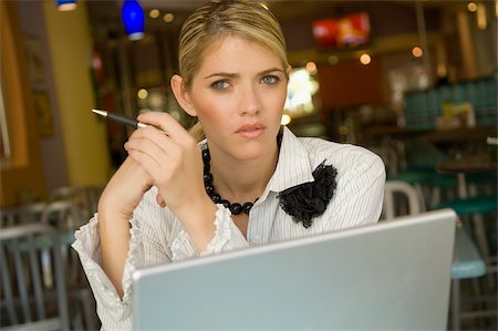 Portrait of a businesswoman sitting in front of a laptop in a restaurant Stock Photo - Premium Royalty-Free, Code: 625-02930818