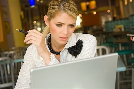 Businesswoman using a laptop in a restaurant Stock Photo - Premium Royalty-Free, Code: 625-02930819