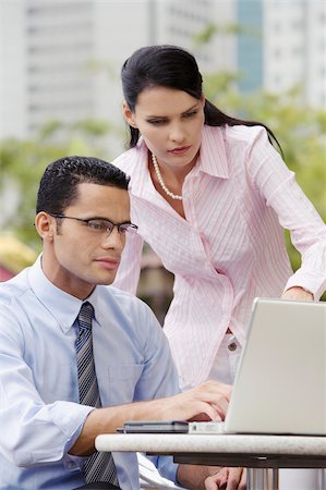 simsearch:630-03481503,k - Businessman using a laptop with a businesswoman standing beside him Fotografie stock - Premium Royalty-Free, Codice: 625-02930811