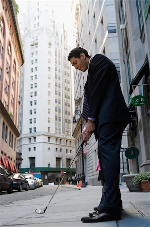 Side profile of a businessman playing golf on the road Foto de stock - Sin royalties Premium, Código: 625-02930845