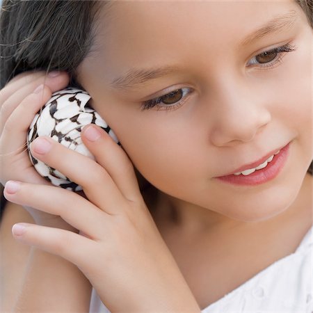 Close-up of a girl listening to shell Stock Photo - Premium Royalty-Free, Code: 625-02930869