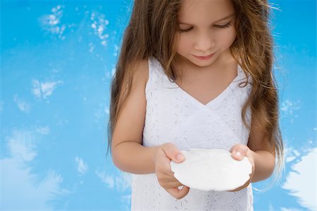 Close-up of a girl holding a seashell Foto de stock - Royalty Free Premium, Número: 625-02930890