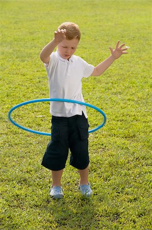 plastic to energy - Boy playing with a plastic hoop in a park Stock Photo - Premium Royalty-Free, Code: 625-02930904