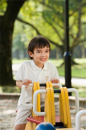 simsearch:700-00910950,k - Portrait of a boy sitting on a ride and smiling in a park Foto de stock - Royalty Free Premium, Número: 625-02930919