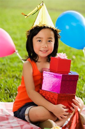 simsearch:642-01735641,k - Portrait d'une jeune fille tenant une pile de cadeaux d'anniversaire et souriant dans un parc Photographie de stock - Premium Libres de Droits, Code: 625-02930910