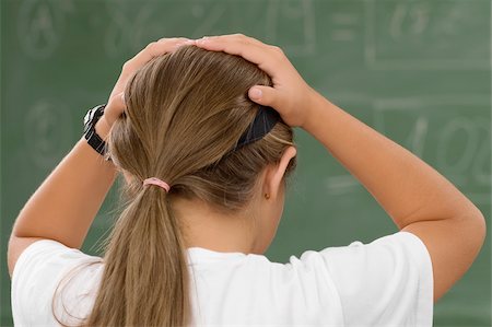 simsearch:625-01249782,k - Rear view of a schoolgirl with her hands in her hair Fotografie stock - Premium Royalty-Free, Codice: 625-02930951