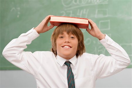 simsearch:625-02930319,k - Portrait of a schoolboy holding a book over his head and smiling Stock Photo - Premium Royalty-Free, Code: 625-02930977
