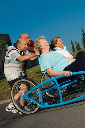simsearch:625-02932654,k - Two senior women sitting on a quadracycle and two senior men pushing it Foto de stock - Royalty Free Premium, Número: 625-02931013