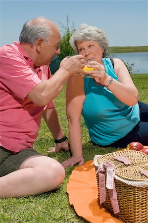 simsearch:859-03037419,k - Senior couple holding glasses of juice at picnic Fotografie stock - Premium Royalty-Free, Codice: 625-02931090