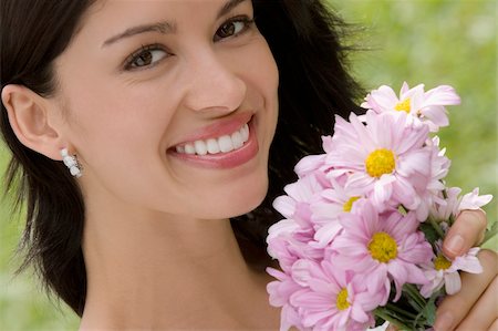 Portrait of a young woman holding a bouquet of flowers and smiling Foto de stock - Sin royalties Premium, Código: 625-02931124