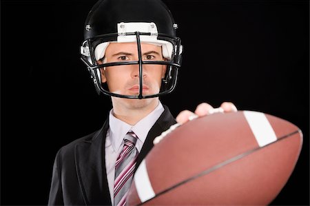 simsearch:625-02931241,k - Close-up of a businessman wearing a football helmet Fotografie stock - Premium Royalty-Free, Codice: 625-02931248